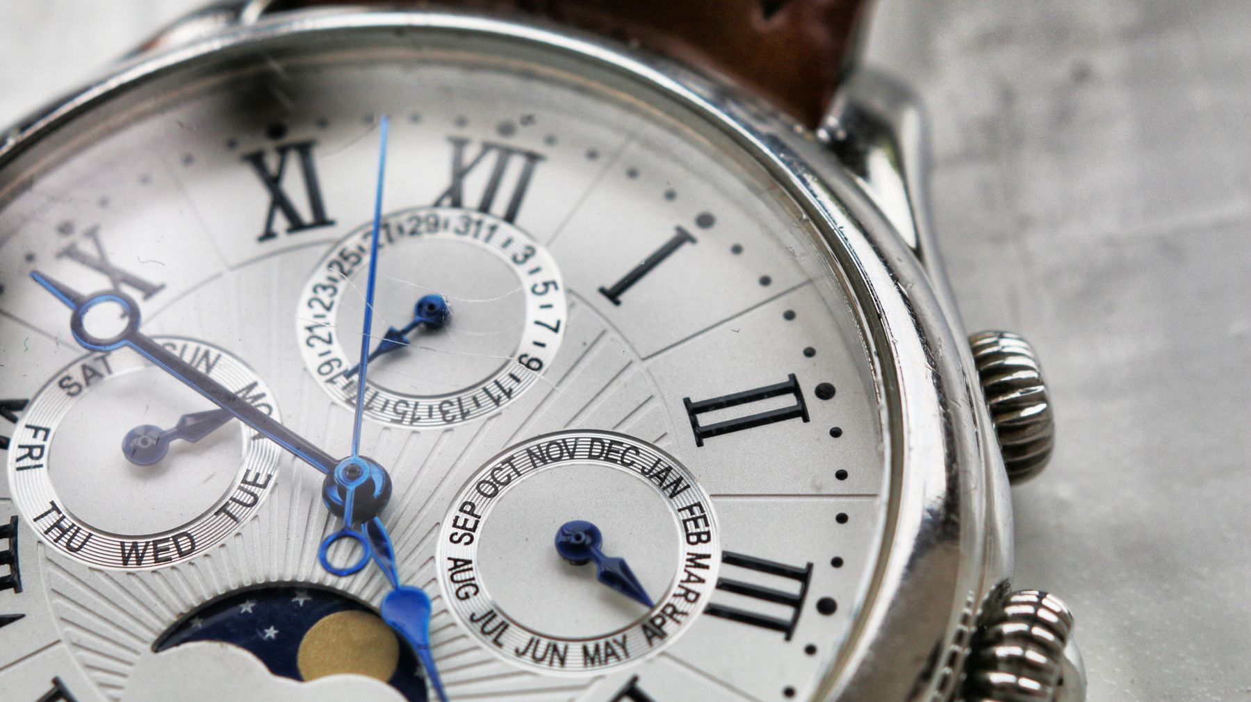 Close-up of a silver moonphase wristwatch dial