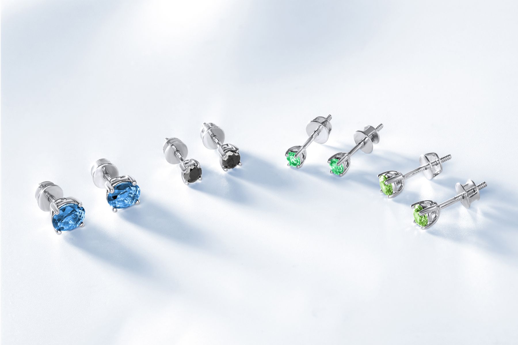 Silver gemstone stud earrings arranged on a white surface